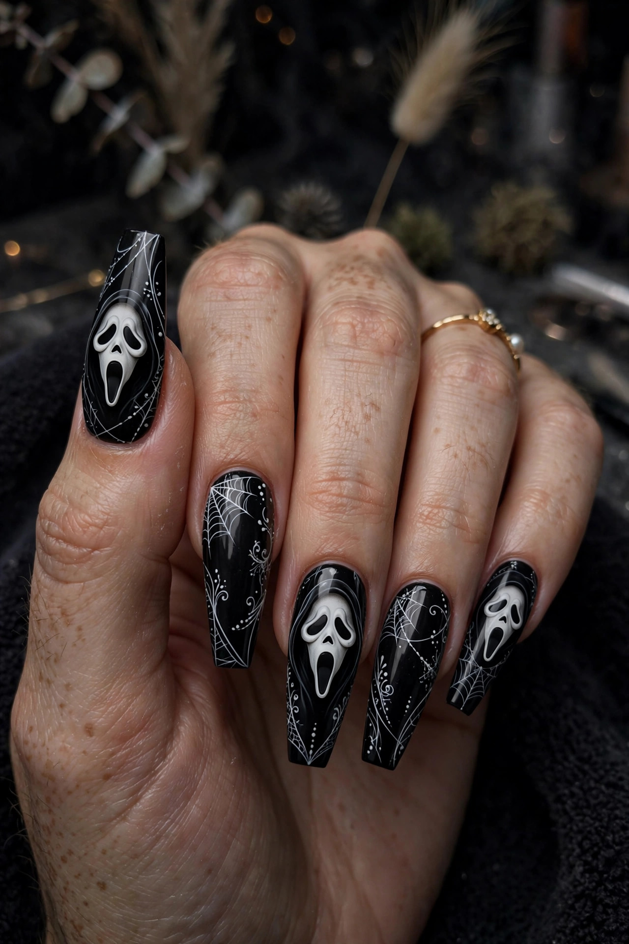 Teen hand with long coffin acrylic nails and detailed Ghostface nail art