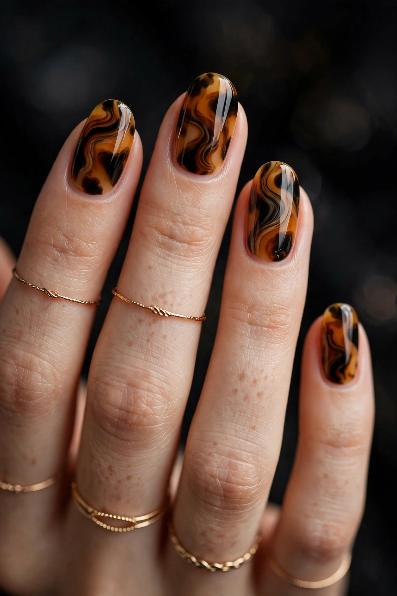Tortoiseshell patterned nails with gold rings